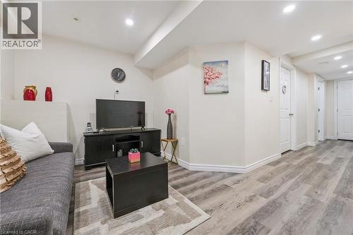Spacious lower-level living area featuring recessed lighting, light wood-finish flooring, and white baseboards - 36 Van Fleet Terrace, Milton, ON - Indoor