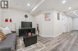 Spacious lower-level living area featuring recessed lighting, light wood-finish flooring, and white baseboards - 