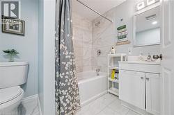 Bathroom featuring a white vanity with integrated sink, a built-in tub with tile surround, and a wall-mounted mirror - 