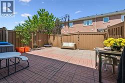 Paved patio area featuring brick-patterned pavers and wood fencing - 