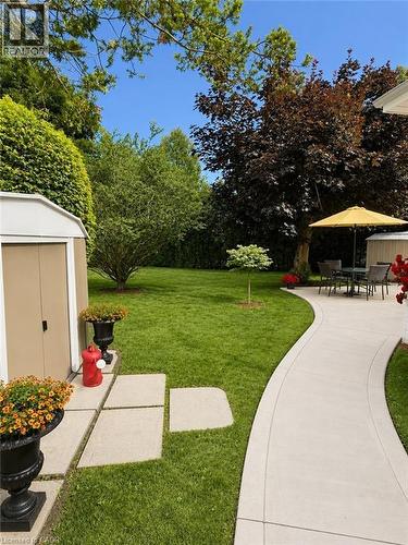 Expansive lawn area featuring a curved concrete pathway and a patio space - 23 Percy Court, Hamilton, ON - Outdoor