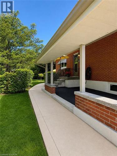 Inviting covered front porch with brick accents, concrete steps, and a concrete walkway - 23 Percy Court, Hamilton, ON - Outdoor