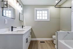 Bathroom featuring a double vanity with white cabinetry, white countertop, and matte black hardware - 