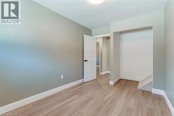 Interior room featuring light wood-finish flooring, light green wall paint, and white trim - 