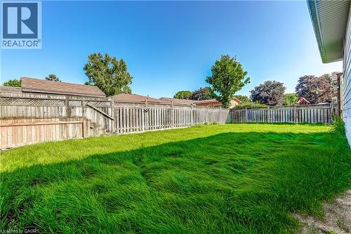 Expansive grassy yard with full wood perimeter fencing and mature trees - 191 Glenmor Drive, Caledonia, ON - Outdoor With Backyard