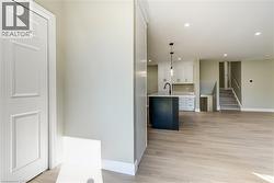 Open-concept living space featuring wood-finish flooring and light-toned walls - 