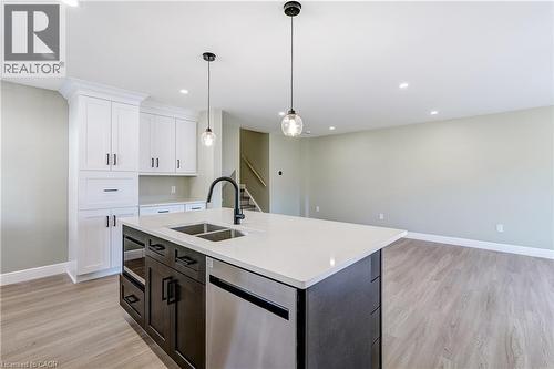 Kitchen island with a dual-basin stainless steel sink, matte black faucet, and two pendant lights - 191 Glenmor Drive, Caledonia, ON - Indoor Photo Showing Kitchen With Double Sink With Upgraded Kitchen