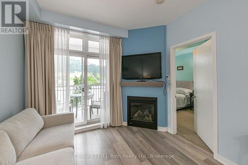 Walk out to balcony - Suite 206 - 40 Horseshoe Boulevard, Oro-Medonte (Horseshoe Valley), ON - Indoor Photo Showing Living Room With Fireplace