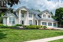 Two-story residence featuring light-colored stone exterior and a dark-colored shingled roof - 44 St Andrew'S Drive, Brantford, ON  - Outdoor With Facade 