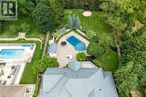 Expansive rear yard featuring a paved patio, an in-ground swimming pool, a putting green, mature landscaping, and a detached shed - 44 St Andrew'S Drive, Brantford, ON - Outdoor With In Ground Pool