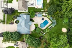 Expansive property featuring a large residence with a multi-gabled roof, an irregular-shaped pool, a putting green, a sand trap, and extensive landscaping - 