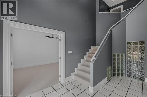 Entryway featuring a carpeted staircase, extensive glass block accents, and light-toned tile flooring - 44 St Andrew'S Drive, Brantford, ON - Indoor Photo Showing Other Room