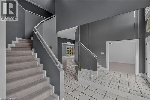 Curved staircase with carpeted treads and white risers, complemented by a white handrail - 44 St Andrew'S Drive, Brantford, ON - Indoor Photo Showing Other Room