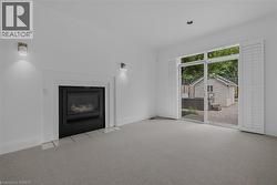 Living area featuring a built-in fireplace with a black insert and tiled hearth, flanked by sconce lighting - 