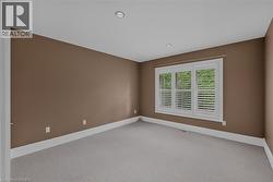 Room featuring a window with white louvered shutters, recessed lighting, wall-to-wall carpeting, and baseboard trim - 
