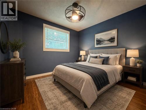 Room featuring wood-finish flooring, a contemporary ceiling fan, and a single window with blinds - 41 Edgemere Drive, Cambridge, ON - Indoor Photo Showing Bedroom
