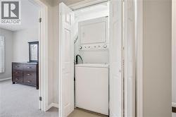 Dedicated laundry closet featuring a stacked washer and dryer - 