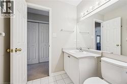 Bathroom featuring a vanity with an integrated sink, a large mirror, and overhead lighting - 