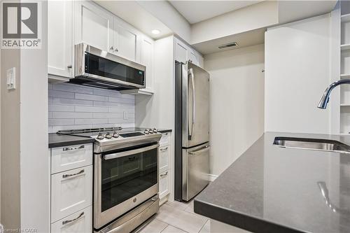 Kitchen featuring white shaker cabinetry, stainless steel appliances, dark countertops, a white subway tile backsplash, and recessed lighting - 711 Johnston Park Avenue, Collingwood, ON - Indoor Photo Showing Kitchen With Upgraded Kitchen