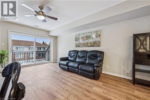Living area featuring wood-finish flooring, a ceiling fan with integrated lighting, and a sliding glass door providing balcony access - 711 Johnston Park Avenue, Collingwood, ON - Indoor Photo Showing Living Room