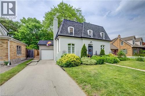 White stucco exterior with a dark gambrel roof, three dormer windows, and a prominent chimney - 314 Glasgow Street, Kitchener, ON - Outdoor