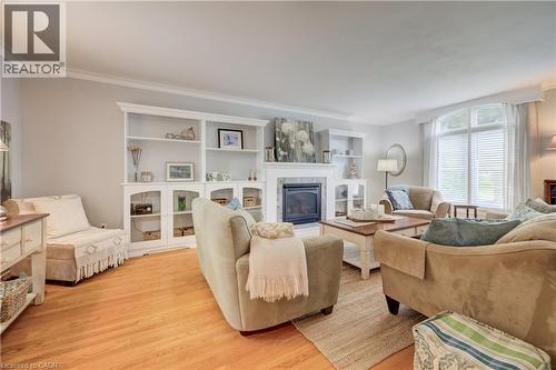 Living area with wood-finish flooring, a fireplace featuring a tile surround, and built-in shelving - 314 Glasgow Street, Kitchener, ON - Indoor Photo Showing Living Room With Fireplace