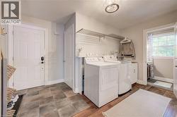 Dedicated laundry area featuring a washer and dryer, an overhead drying rack, and a built-in utility sink - 