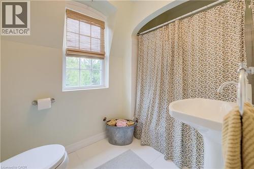 Bathroom featuring a pedestal sink, white tile flooring, and a window with a woven wood shade - 314 Glasgow Street, Kitchener, ON - Indoor Photo Showing Bathroom