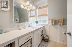 Vanity area featuring a wide countertop, integrated sink, and white cabinetry with brushed nickel hardware - 