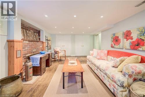 Living area featuring wood-finish flooring, recessed lighting, and a brick fireplace with a wood mantel - 314 Glasgow Street, Kitchener, ON - Indoor Photo Showing Living Room