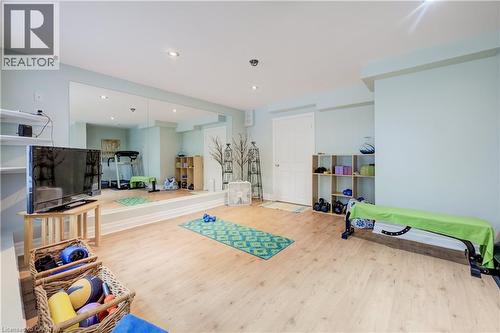 Spacious interior room featuring light wood-finish flooring, a full-wall mirror, recessed lighting, and light blue wall tones - 314 Glasgow Street, Kitchener, ON - Indoor