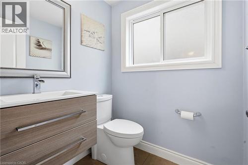 Bathroom featuring a floating wood-finish vanity with an integrated white sink and a chrome faucet - 19 Alona Avenue, Cambridge, ON - Indoor Photo Showing Bathroom
