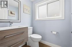 Bathroom featuring a floating wood-finish vanity with an integrated white sink and a chrome faucet - 