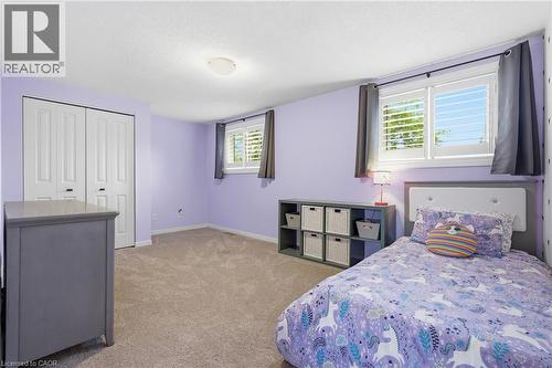 Bedroom featuring two windows with white plantation shutters and dark gray curtain panels, light purple walls, and neutral carpet flooring - 19 Alona Avenue, Cambridge, ON - Indoor Photo Showing Bedroom