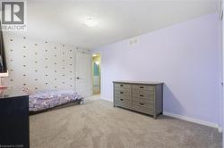 Carpeted room featuring a white door with black hardware, a ceiling-mounted light fixture, and textured ceiling - 