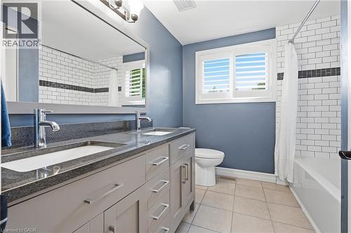Bathroom featuring a double vanity with polished chrome fixtures and stone countertops - 19 Alona Avenue, Cambridge, ON - Indoor Photo Showing Bathroom