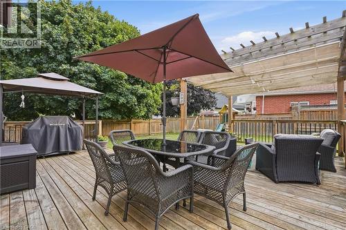 Expansive outdoor wood deck featuring a pergola with a retractable shade cover, wood privacy fencing, and mature surrounding trees - 19 Alona Avenue, Cambridge, ON - Outdoor With Deck Patio Veranda With Exterior