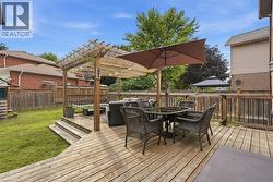 Multi-level wood deck featuring a pergola, wood railings, and stairs leading to a grassy yard - 