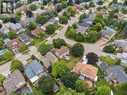 Residential neighborhood featuring a cul-de-sac, mature trees, and multiple properties with private swimming pools - 