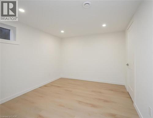 Bedroom featuring light-tone wood-finish flooring, recessed lighting, and a white paneled door - 781 Ninth Avenue Unit# Lower, Hamilton, ON - Indoor Photo Showing Other Room