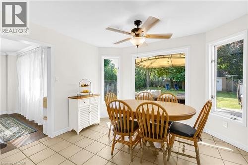 Dining area featuring light-toned tile flooring, a ceiling fan with integrated lighting, and multiple windows - 123 Benn Drive, Cambridge, ON - Indoor Photo Showing Dining Room