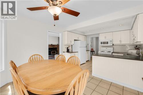 Eat-in kitchen featuring white cabinetry, dark countertops, a tile backsplash, and tile flooring - 123 Benn Drive, Cambridge, ON - Indoor Photo Showing Other Room