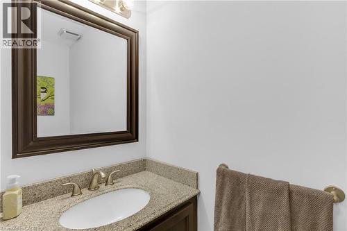 Bathroom vanity featuring a framed mirror, granite countertop, undermount sink, and brushed nickel fixtures - 123 Benn Drive, Cambridge, ON - Indoor Photo Showing Bathroom