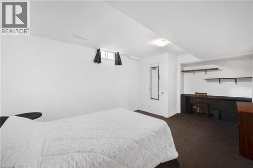 Spacious room featuring white walls, dark carpet flooring, and a built-in desk with shelving - 123 Benn Drive, Cambridge, ON - Indoor Photo Showing Bedroom