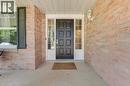 Brick exterior with a paneled black door, sidelight windows, and a covered porch entry - 123 Benn Drive, Cambridge, ON  - Outdoor With Exterior 