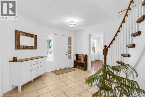 Foyer featuring tile flooring, a white front door with sidelight windows, and a staircase with wood treads and white balusters - 123 Benn Drive, Cambridge, ON - Indoor Photo Showing Other Room