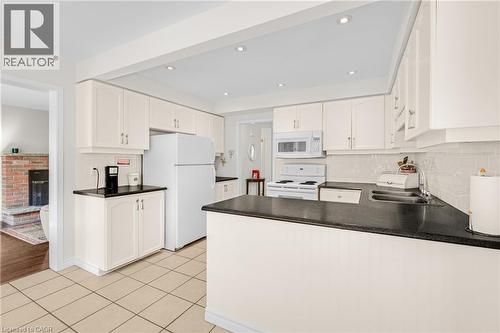Bright kitchen with white cabinetry and dark countertops - 123 Benn Drive, Cambridge, ON - Indoor Photo Showing Kitchen