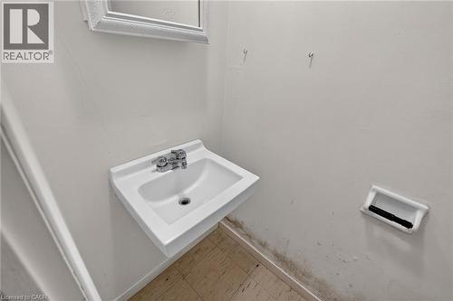 Wall-mounted sink with chrome faucet, framed mirror, and tile flooring - 125 Bonaventure Drive Unit# 50, Hamilton, ON - Indoor Photo Showing Bathroom