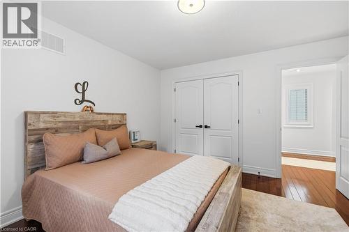 Bright bedroom featuring rich wood-finish flooring and a contemporary overhead light fixture - 199 Hunter Street W, Hamilton, ON - Indoor Photo Showing Bedroom
