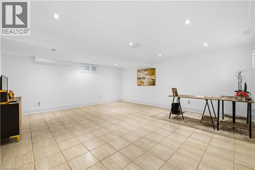 Spacious interior room featuring light-toned square floor tiles and white painted walls - 199 Hunter Street W, Hamilton, ON - Indoor Photo Showing Other Room